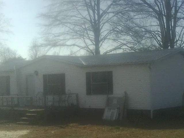 New metal roof on a white painted brick home on a foggy morning in Levittown