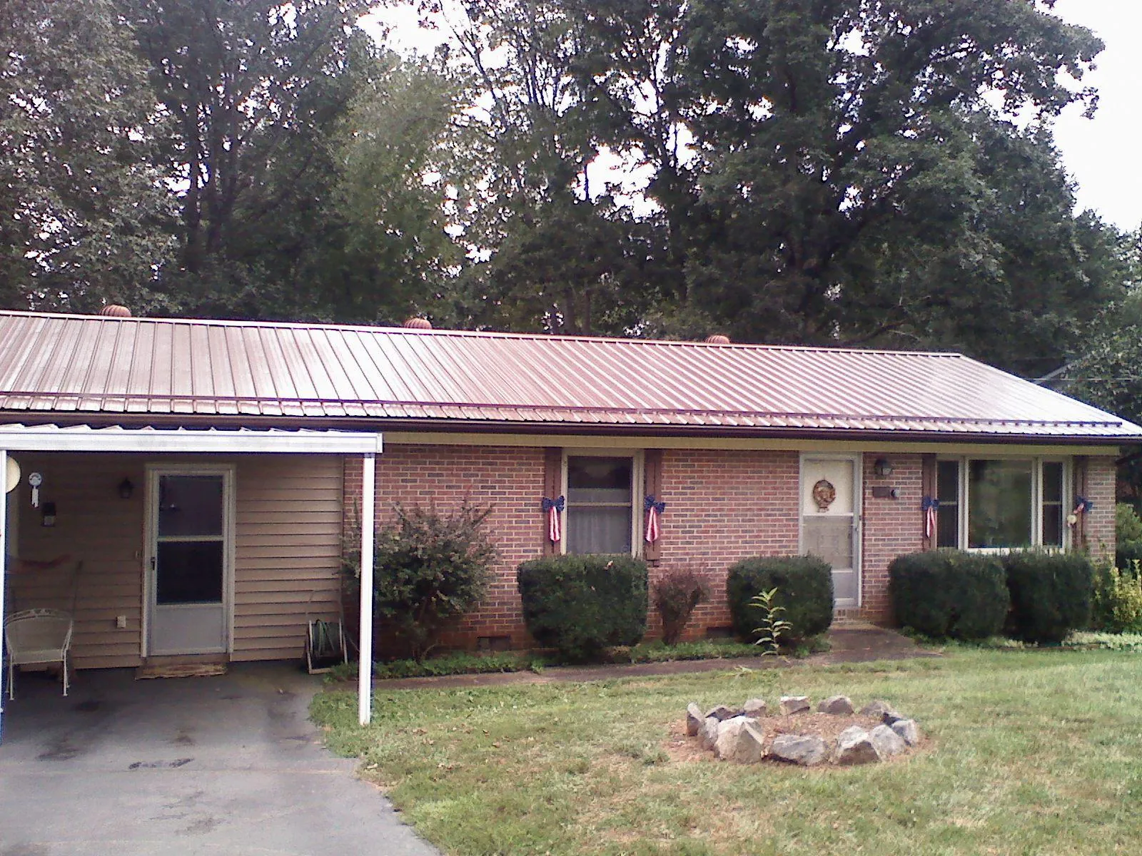 Bronze metal roof and carport on a brick ranch home — Roof Repair work by our crew in Levittown